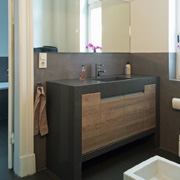 Schön kombiniert: Waschtisch aus Naturstein mit Holzfront